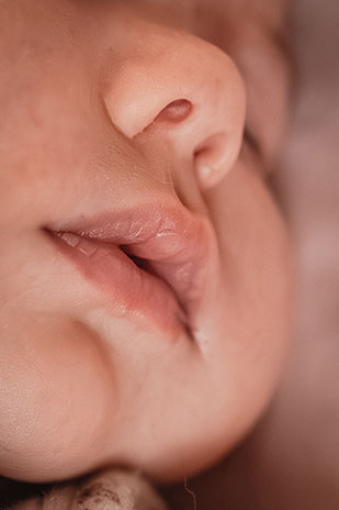 photo du visage d'un nouveau né lors d'une séance photo naissance